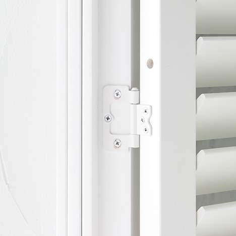 Close-up of a white shutter hinge